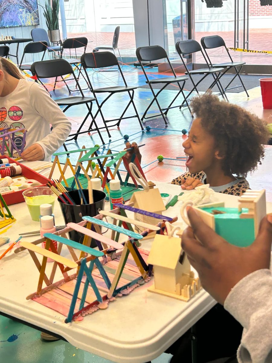 A child building a bridge from craft sticks