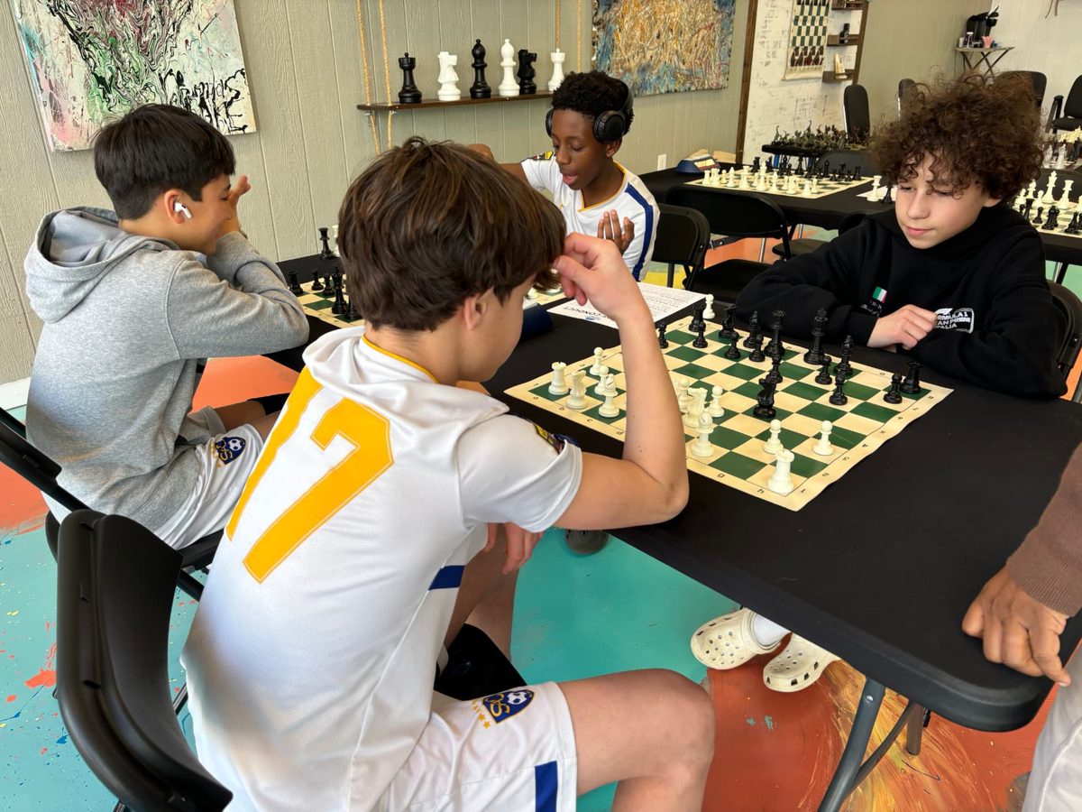 Young players focused on a chess match at Discovery